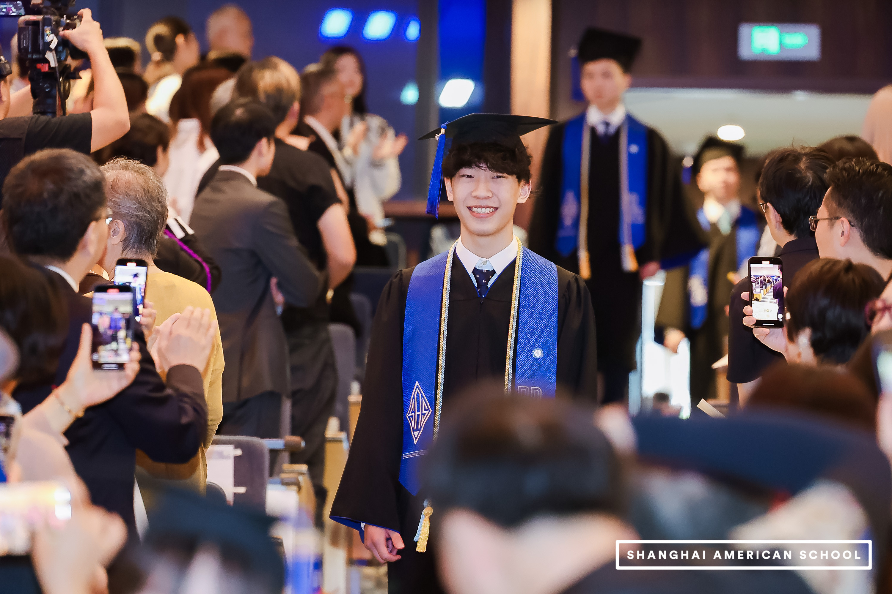 Ethan Jin walking through a graduation crowd